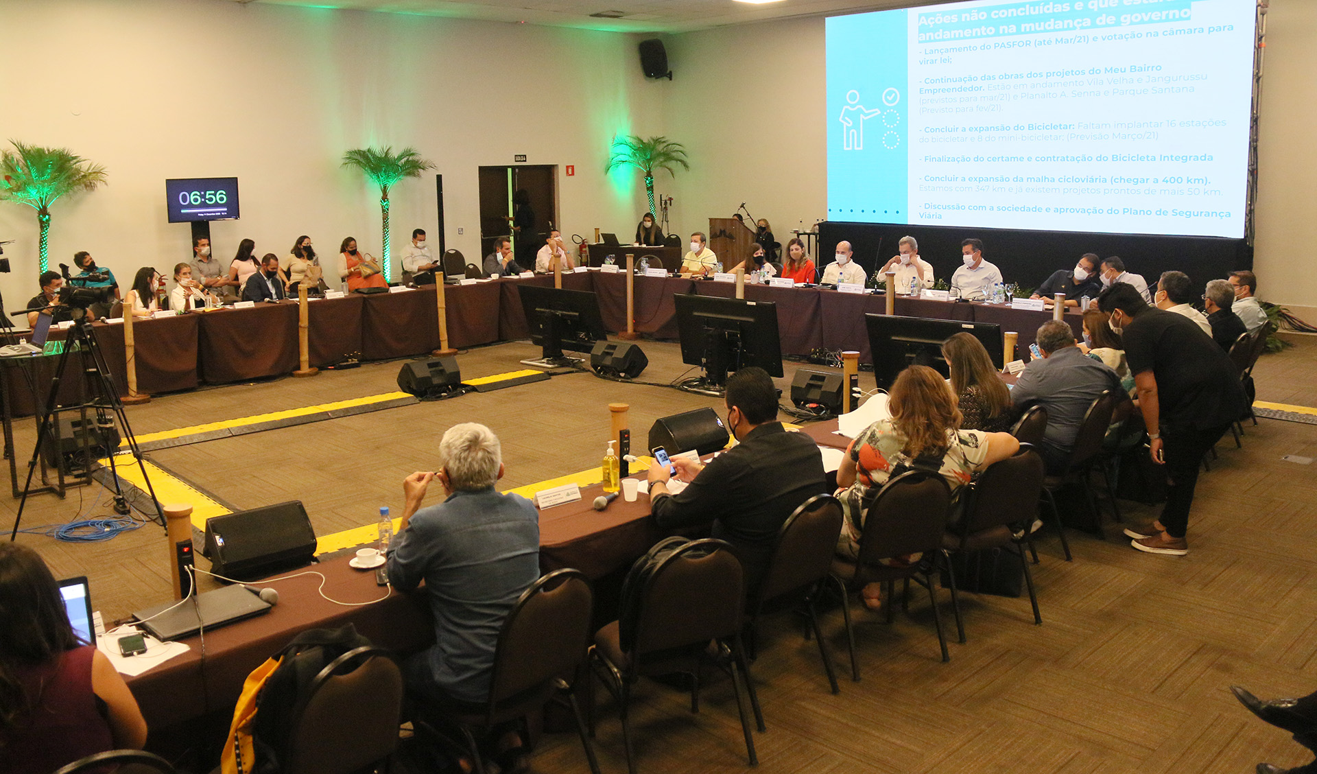 grupo de pessoas sentado em uma mesa de reunião em um salão